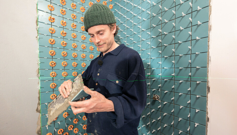 Albert knoklede med at
sætte badeværelsesfliserne op i ”Nybyggerne”. Det indbragte
parret 20.000 kroner
ekstra til budgettet.