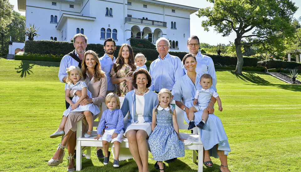 Dronning Silvia sidder centralt placeret i selskab med mand, børn, svigerbørn og børnebørn.