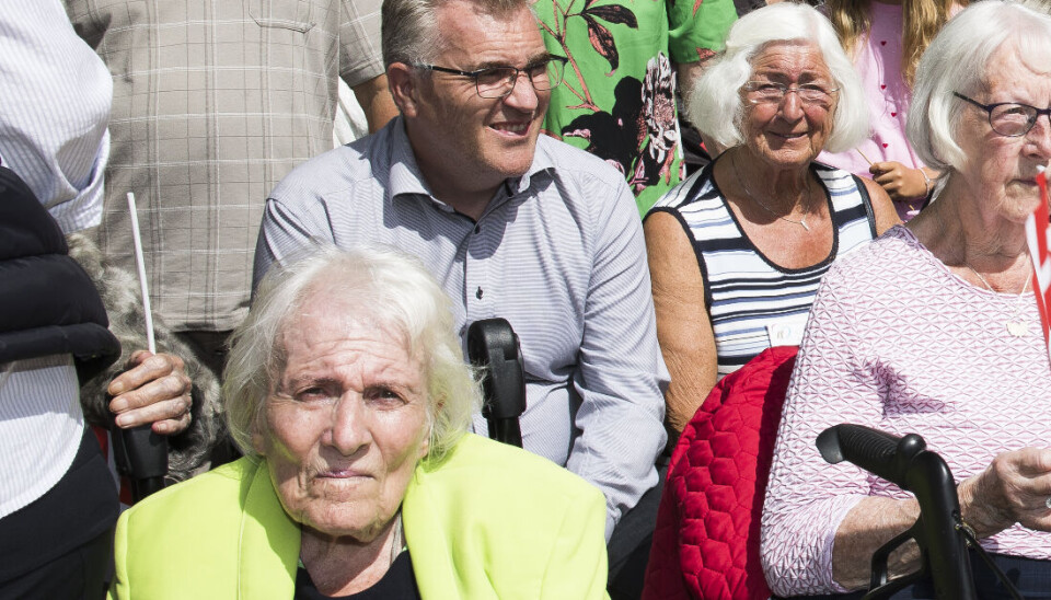 Helga Thaysen ses forrest i den limegrønne jakke, og lige bag hende sønnen, Lars.