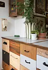 Skuffefronterne i forskellige slags træ, tilsat mange forskellige genbrugsgreb, giver køkkenet masser af personlighed.
