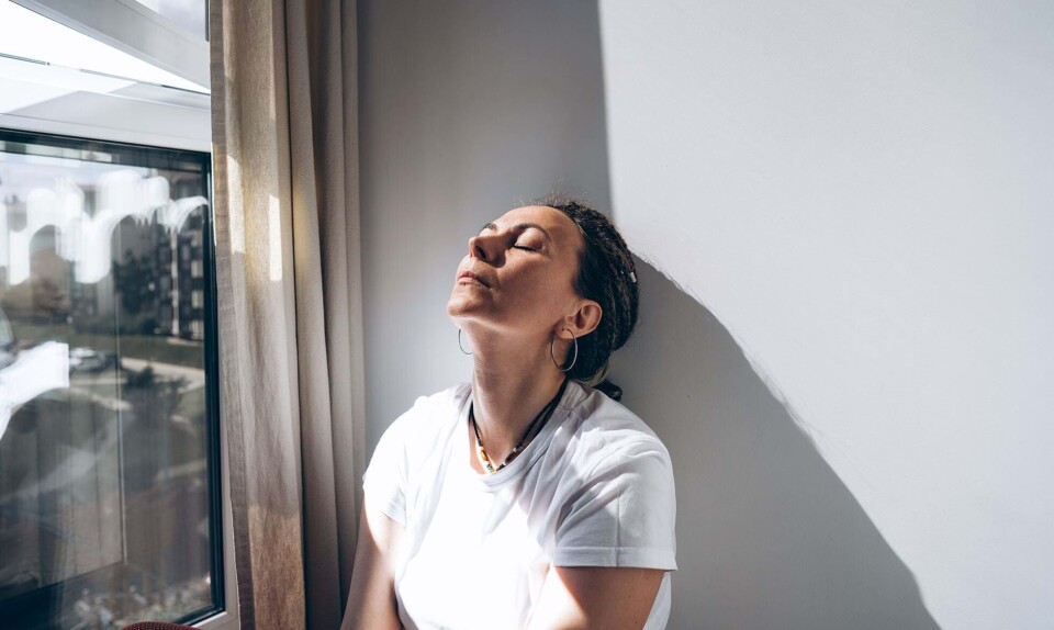 En kvinde i hvid t-shirt, som er ked af det