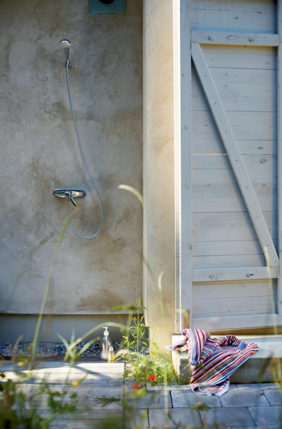 Det udendørs brusebad er noget af det bedste ved huset, for det er noget helt andet at bade udenfor med himlen som tag, synes Tomas.