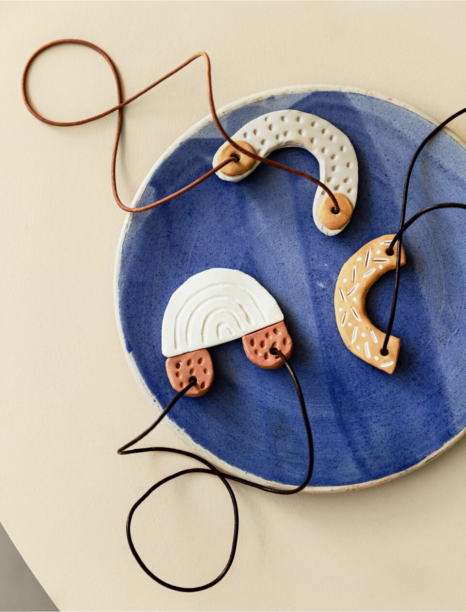 Brug små rester af ler til at lave smykkevedhæng eller julepynt, som sættes på en lædersnor.