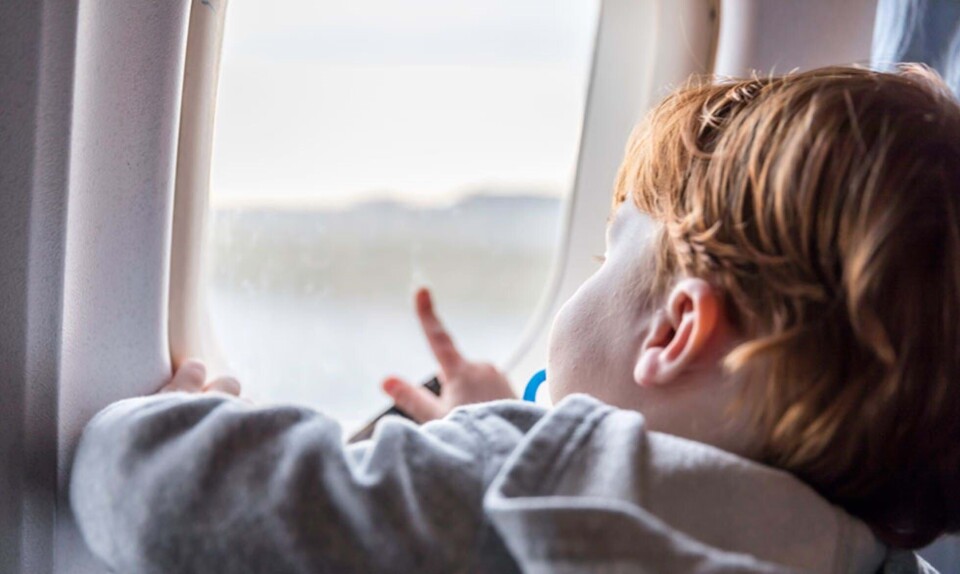 Dreng kigger ud af vinduet i fly