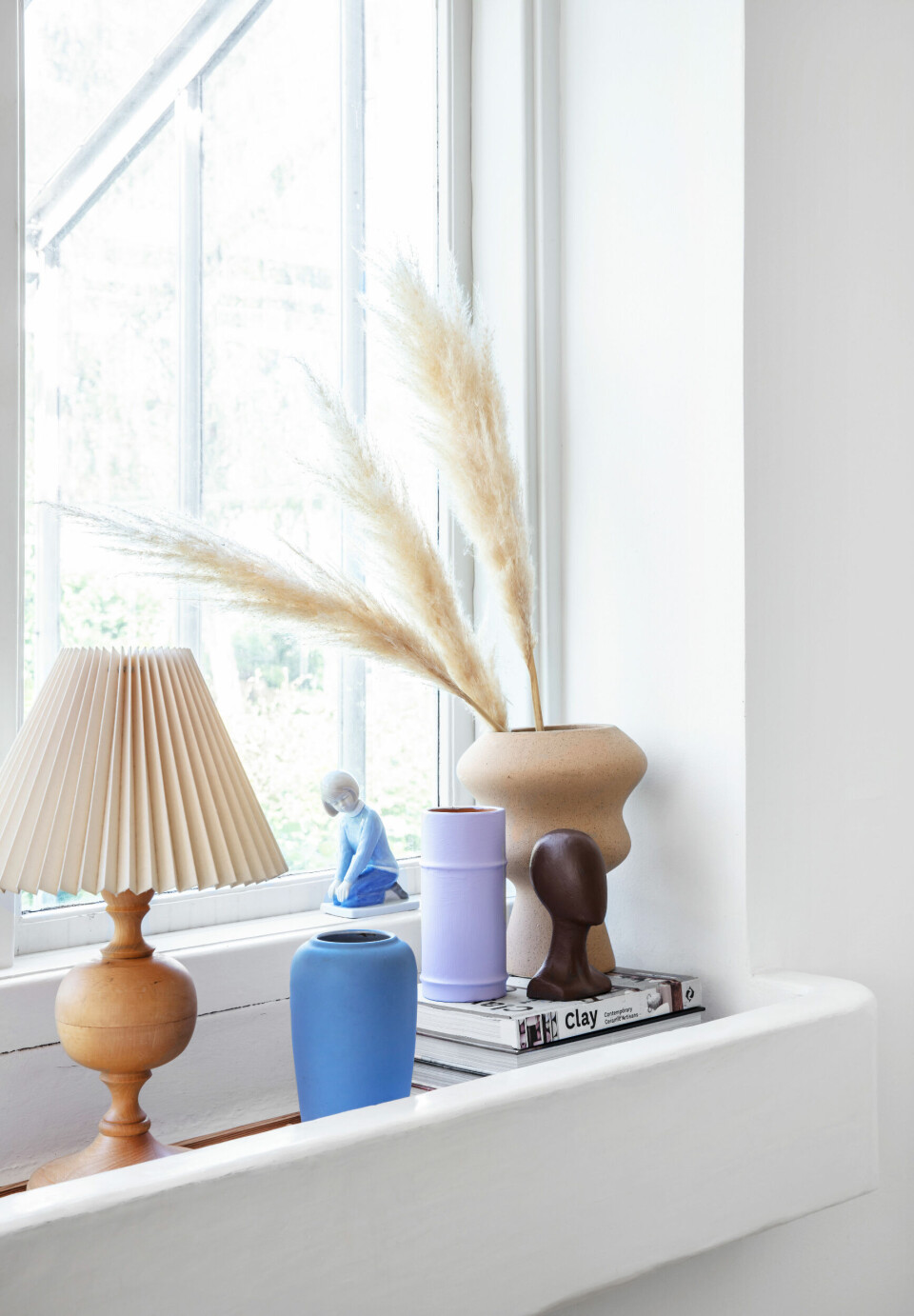 Den store sandfarvede vase er fra IDEmøbler og porcelænsfiguren er fra Royal Copenhagen. Lampen og den øvrige keramik er loppefund.
