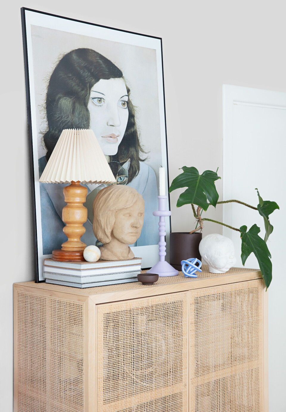 Plakaten er af kunstneren Lucian Freud og fra museumsshoppen på Aros. Den chokoladebrune urtepotte samt den lille skål er fra Ferm Living. Den blåstribede glasskulptur er fra Hay og de to gips– og leransigter er vintage. Tjek @vintage415_ for lignende.