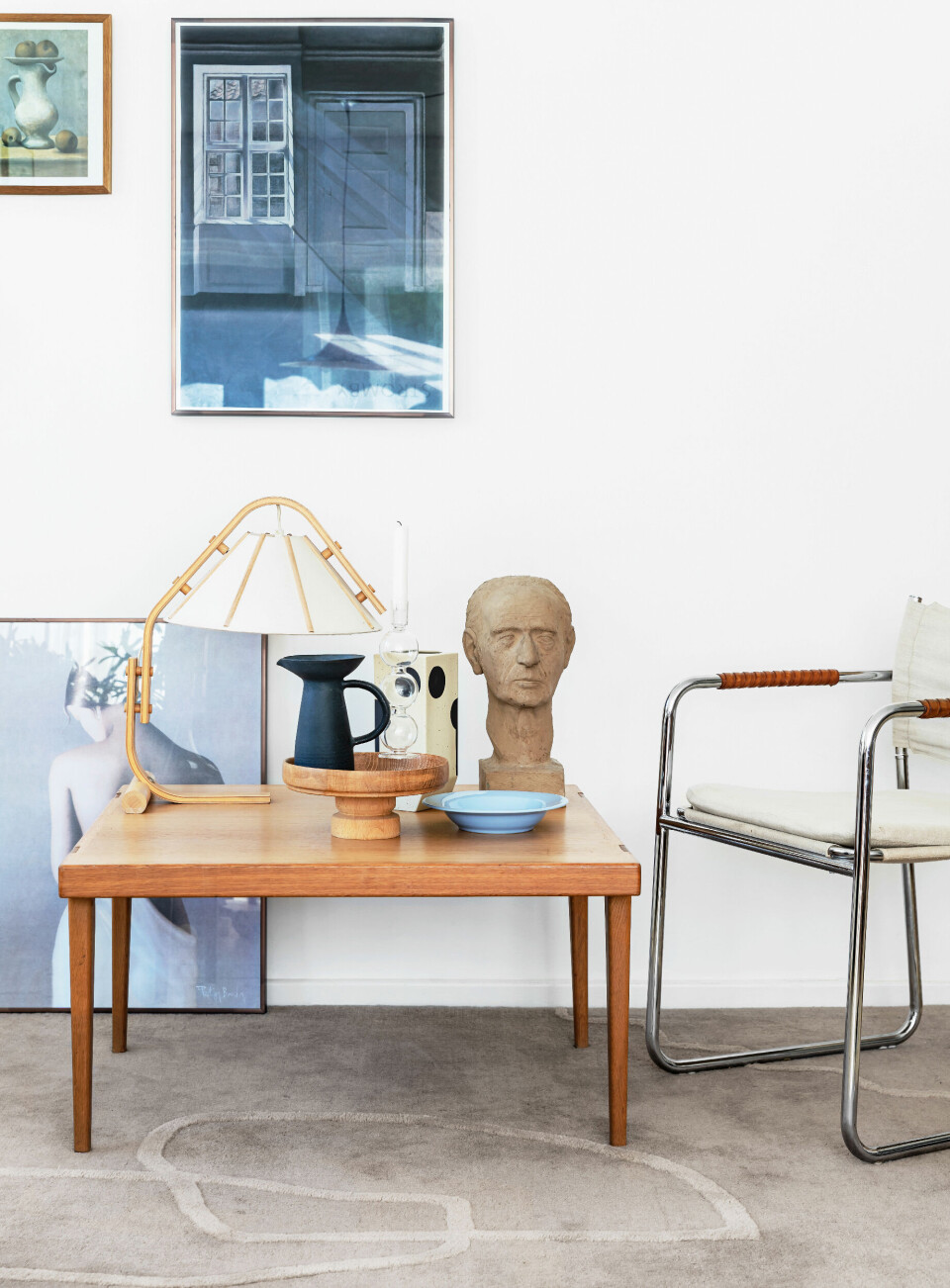 På bordet står en vintagelampe af Jan Wickelstrøm sammen med en smuk kande fra Tina Marie Cph og en vase fra Oyoy. Busten og de øvrige ting er vintage og det samme er stolen, som er designet af Karin Mobring i 1970´erne. Gulvtæppet er fra Ferm Living og plakaten på gulvet er et rejsefund. Hammershøi plakaten er fra museums- shoppen på Ordrupgaard og det lille billede er et Picasso-motiv.