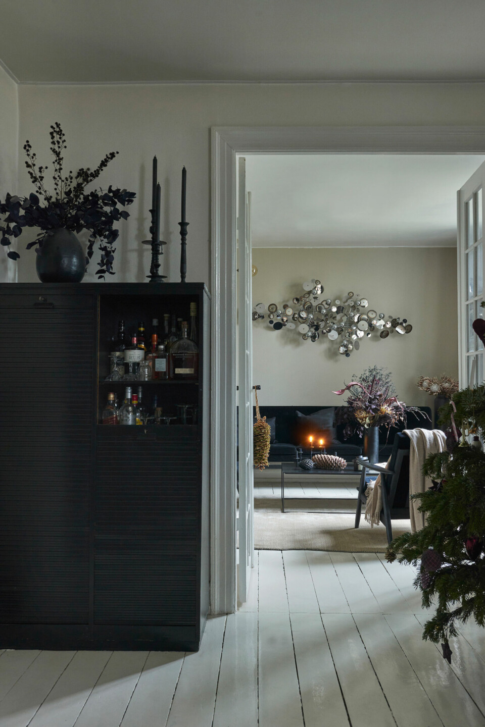 Der er harmonisk og roligt med lyst gulv, grå vægge og sorte møbler i stuen. Den sorte Mayor-sofa er fra &Tradition, mens sofabordet er fra Clarrods Interior.