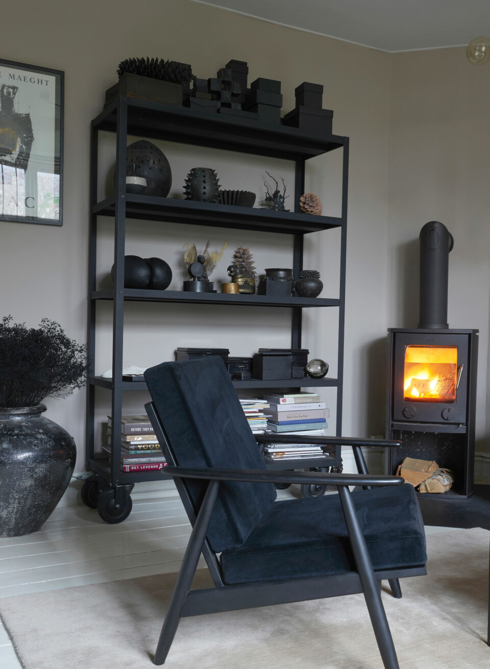 I stuens ene hjørne spreder en brændeovn varme og hygge i Rikkes mørke, dekadente univers.