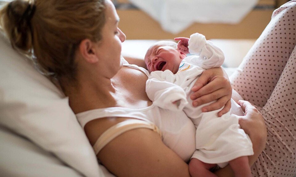 Nybagt mor med grædende baby