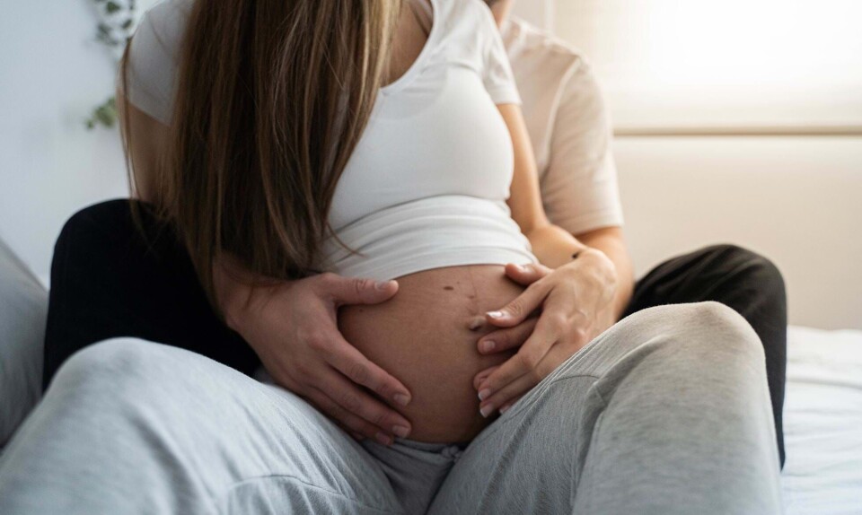 Gravid kvinde og mand holder om hende