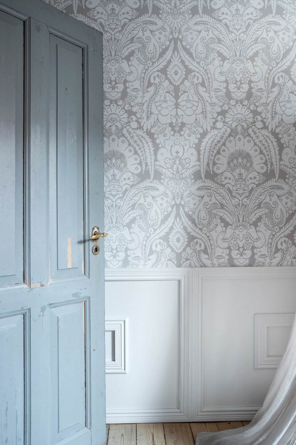 Tapetet er fra Wallpaper Direct. Dørens originale blå farve er bevaret for at give rummet charme.