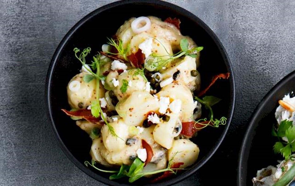 Varm kartoffelsalat med ærteskud, gedefeta og sprødristet serranoskine