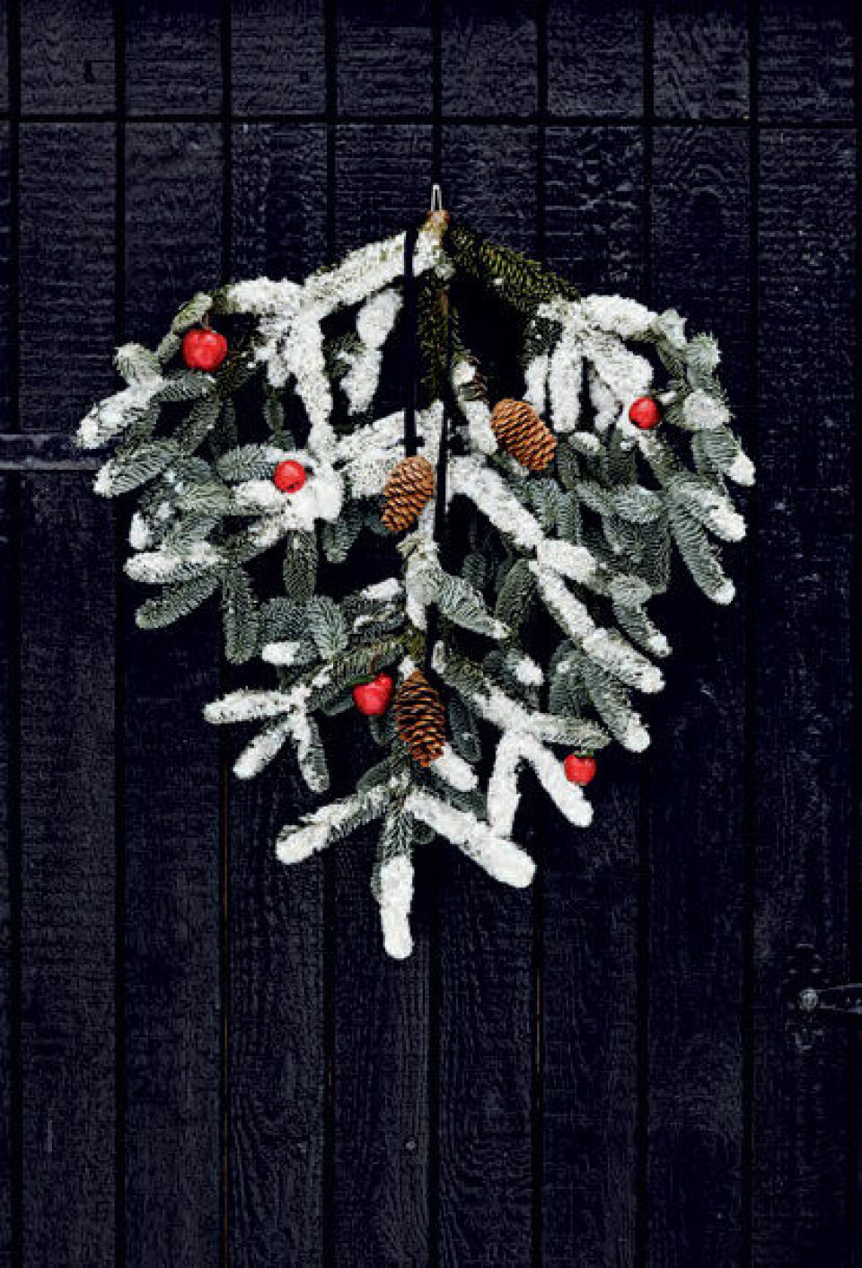 Dyp en fin grangren i sneen, og hæng den op på hoveddøren, plankeværket eller haveskuret. Her