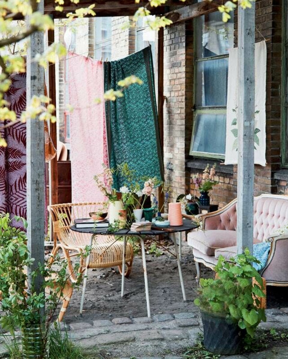 De smukke tæpper, der fungerer som rumdelere, er Signe Emdals egen værker. Sofaen er arvet og kurvemøblerne er fra Sika Design. Se mere på emdalcolorknit.dk