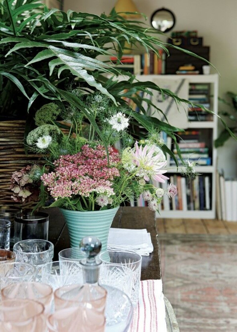 Kelimtæpper og krystalglas sætter stemningen i stuen. Overalt akkompagneret af friske blomster og grønne planter.