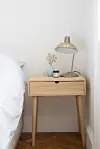 Sengebord i lyst træ til det enkle og hyggelige soveværelse.