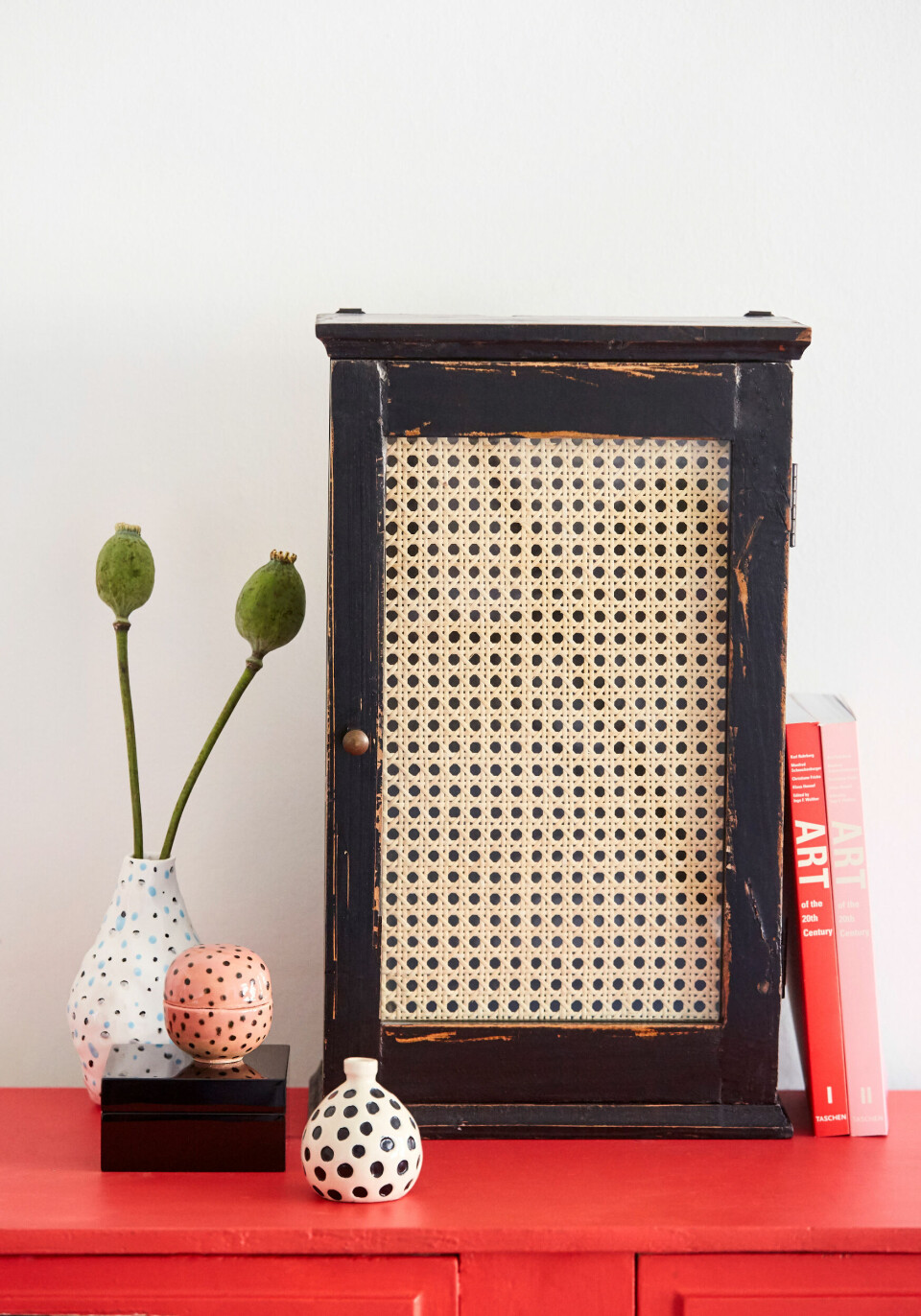 Vasen i baggrunden er fra Hay, den sorte lakæske og lille vase med prikker er fra H&M Home og den lyserøde keramikskål med låg er fra Stilleben.
