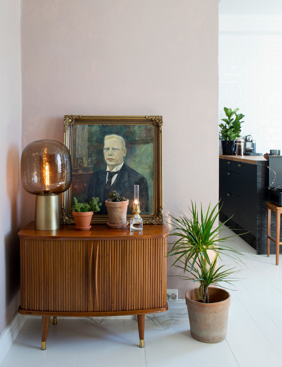 En enkelt væg er malet sart rosa for at bryde med de ellers hvide flader. Farven hedder Keramikk og er fra Jotun. Kommoden er et loppefund og lampen er fra House Doctor.