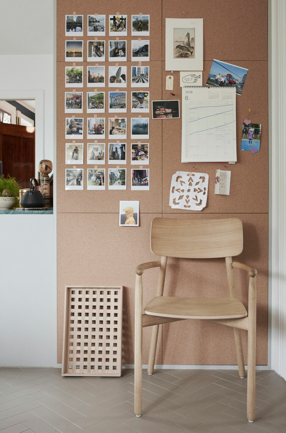 Opslagstavlen er korkfliser og indeholder familiens minder og deres fremtidige planer. Både bakke og stol er fra Skagerak.