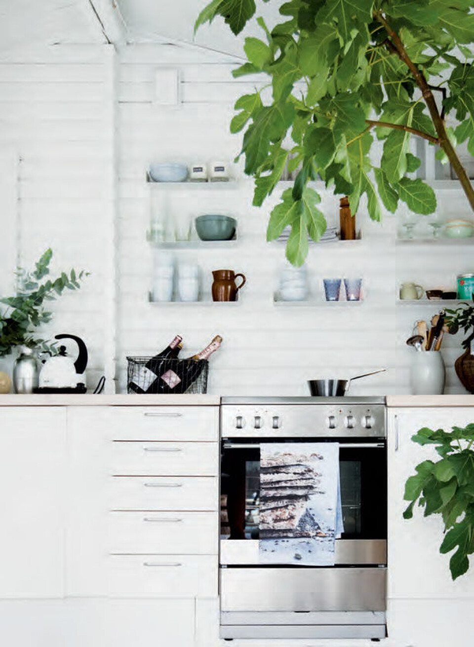 Småt, men godt – det nye, hvide køkken er fra HTH med åbne hylder fra Ikea – fulde af stemningsfuld keramik og grej.