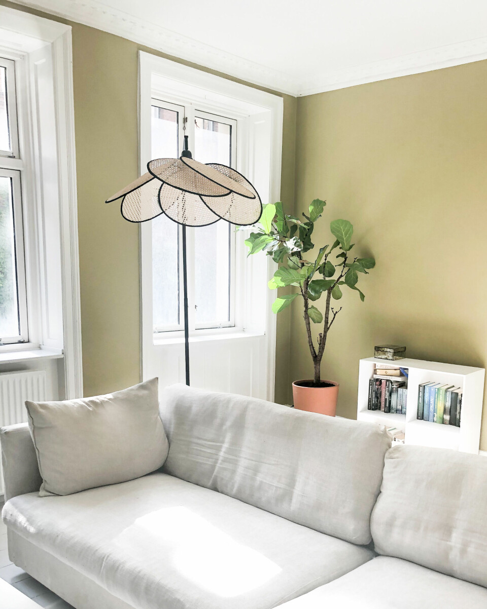 Den lyse sofa er fra Eilersen, lampe fra Les Coulisses, reol fra trævarefabrikernes Udsalg, urtepotte fra IKEA. Farven på væggen er 4326 fra Flügger.