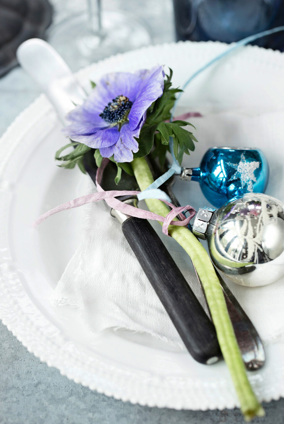 En fransk anemone og et par glaskugler ved hver kuvert ser smukt ud.