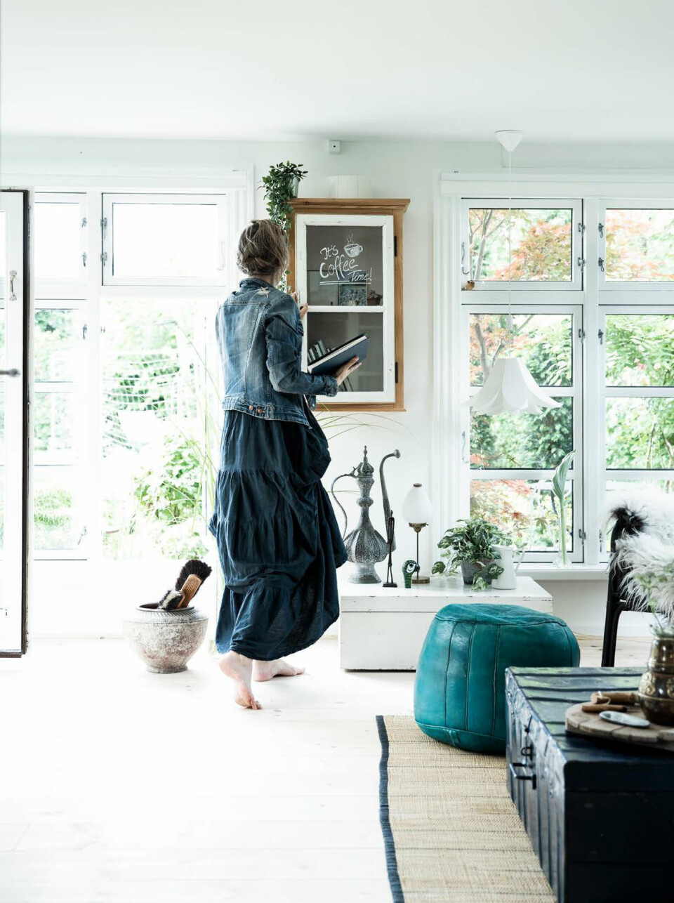 Som en fin detalje i hele huset, er store vinduer isat for at skabe meget lysindfald. I stuen er de sydøstvendt og lyser hele rummet op. Tæppet er håndlavet, puffen er en gave og kufferten har Leena arvet.
