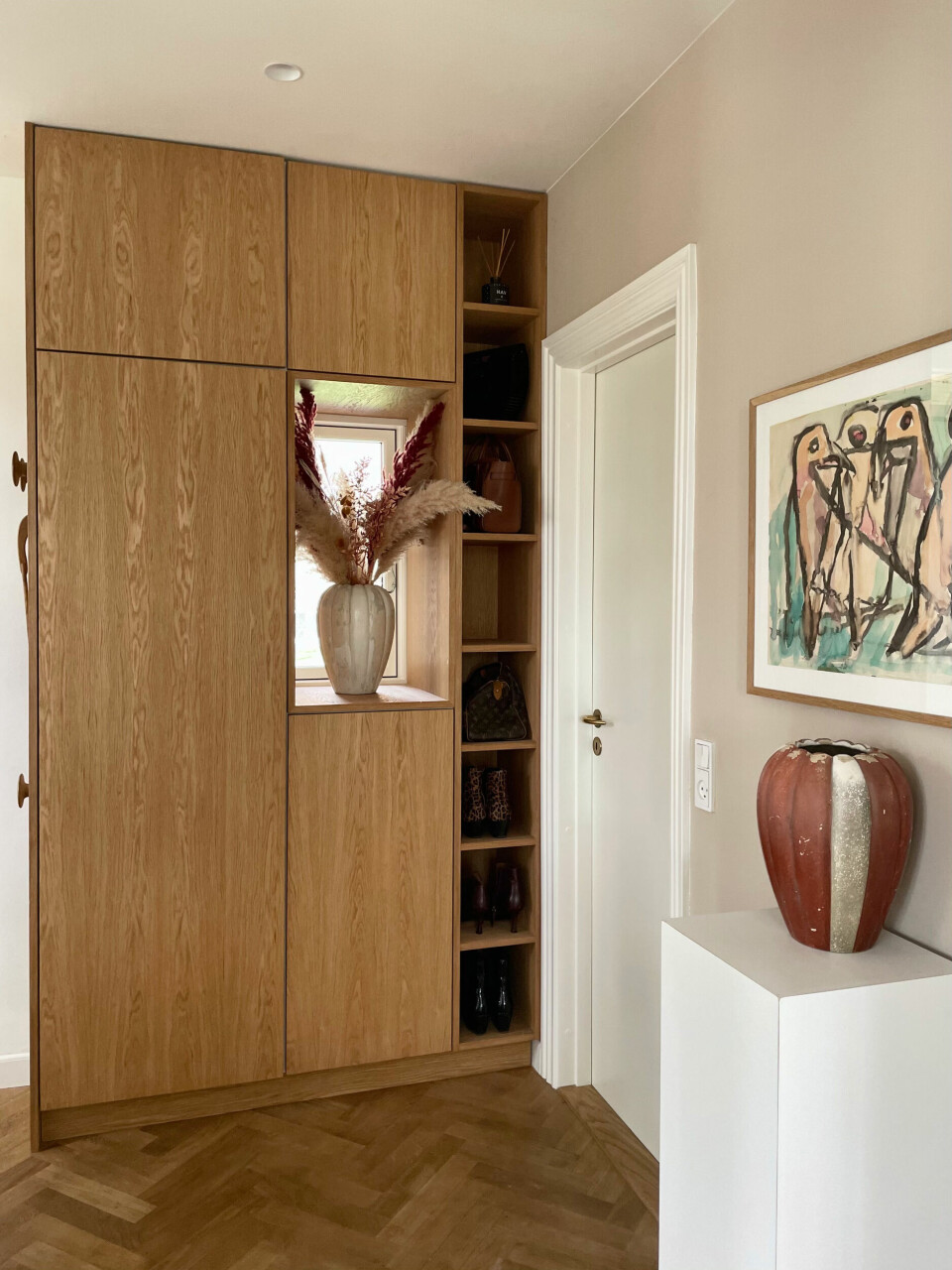 De høje garderobeskabe er til Mette og Henrik, og de lave skabe er til børnene. Reolen til højre er til Mettes tasker og sko.