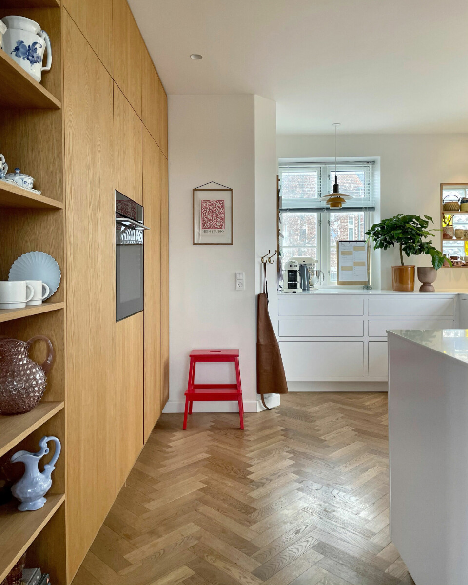 Køkkenvæggen er fra Silkeborg Byg og Design, rød skammel fra IKEA, lampe fra Louis Poulsen og print fra Stilleben.