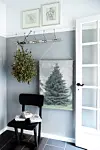 I entreen pynter en stor mistelten side om side med en juletræsplakat fra HK Living. Stolen er ligeledes fra HK Living, og knagerækken er fra Stol & Stage.