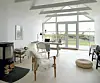 Foran pejsen fra Contura kan Annetteslappe af i den komfortable lænestol. Den flade sivpude er fra Ikea.