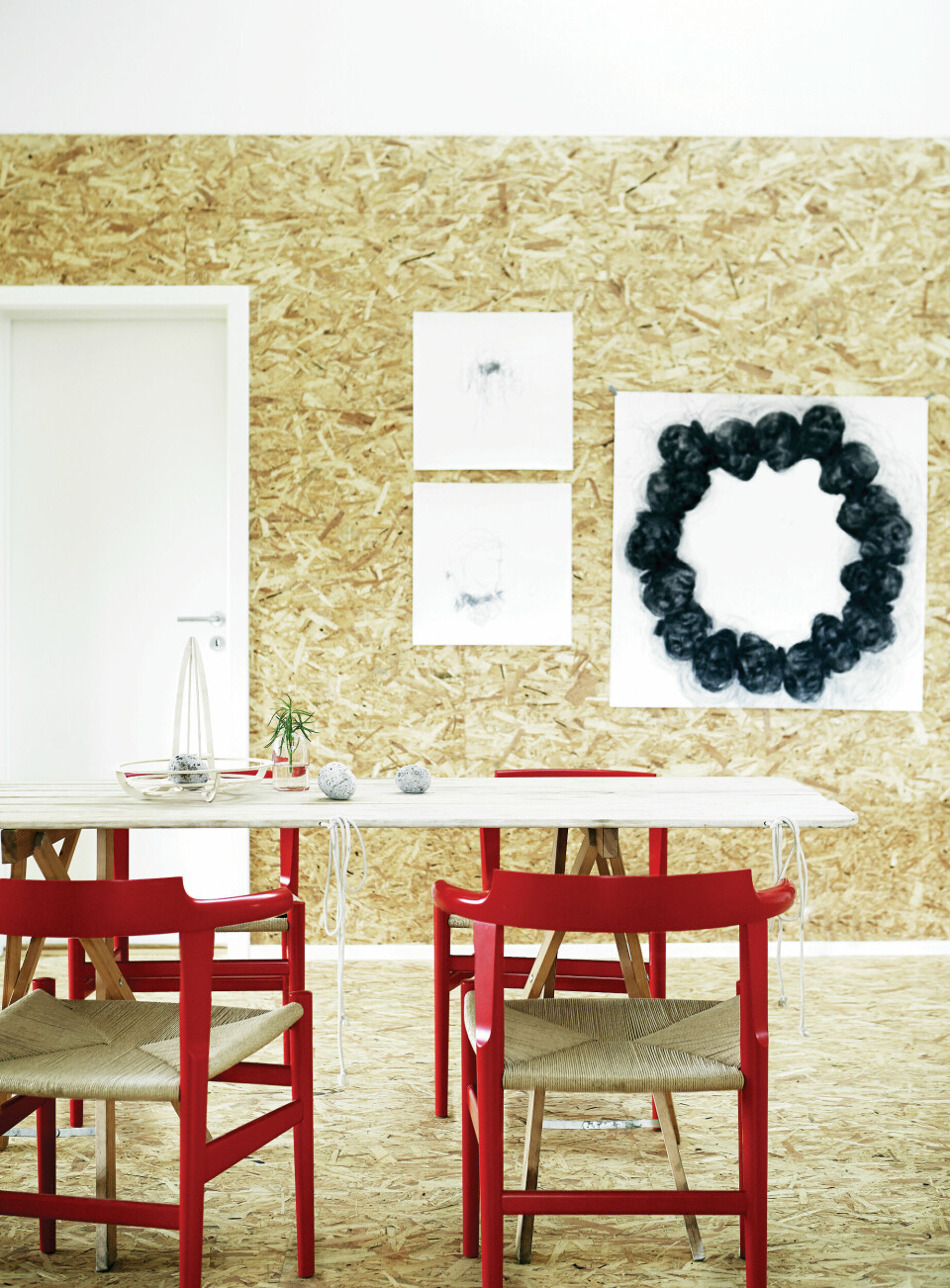 Røde stole fra PP Møbler giver en flo kontrast til de grove spånplader.