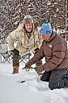James is-fisker på den tilfrosne sø, og Adam tjekker de aborrer, som is-fiskeren Erik har fanget til dem på forhånd for at forkorte tiden. (Foto: Bo Nymann)