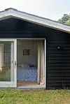 Hvor der før var garage, er der nu indrettet et ekstra soveværelse. Med en stor skydedør kan man hurtigt åbne helt op ud til den skønne natur.
