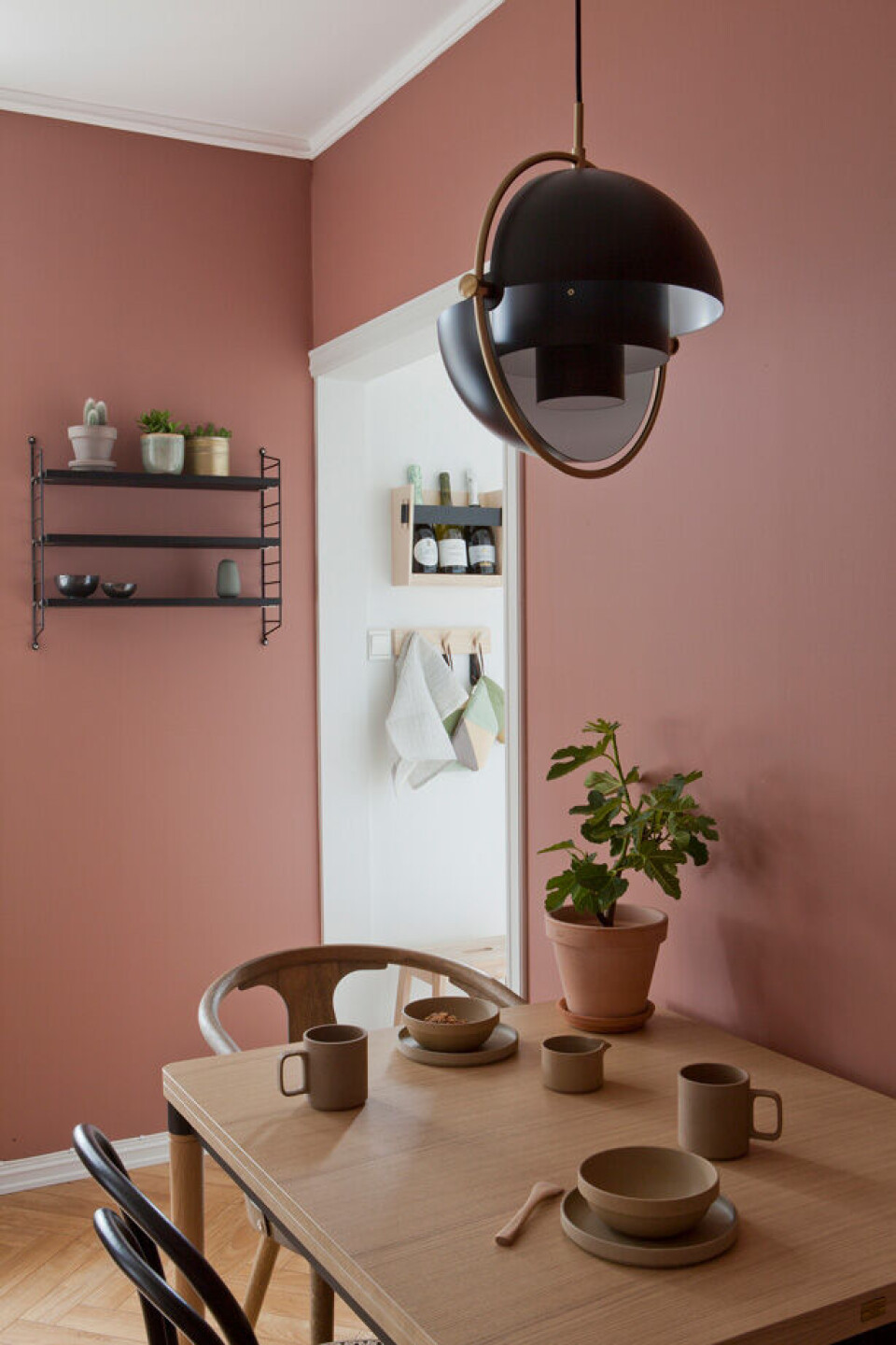 Smuk spiseplads med lampe fra Gubi over.