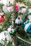 Vintage-julekugler pryder årets træ i samspil med Nannas egne papirrosetter.