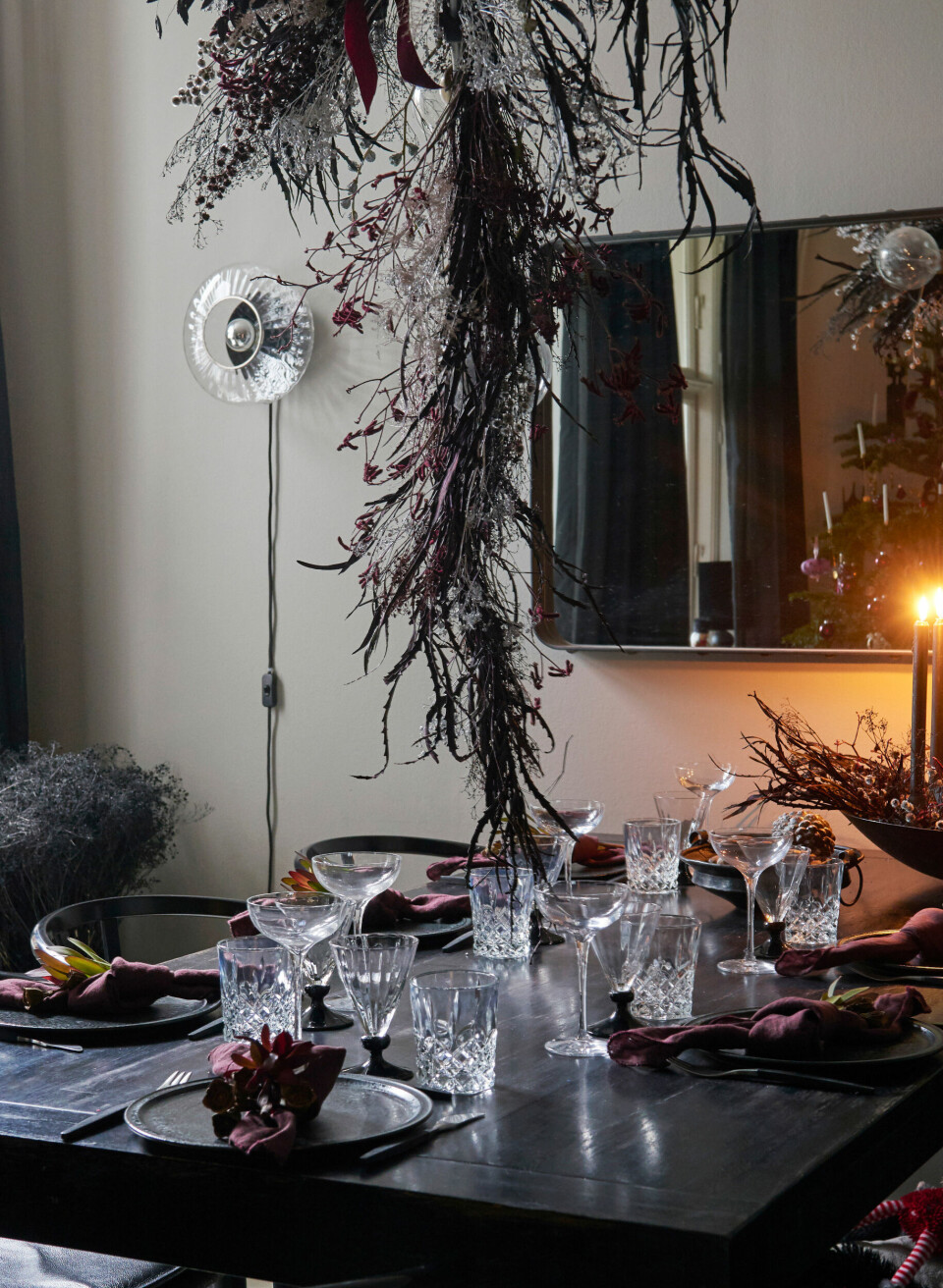 I forlængelse af spisebordet hænger et Adnet-spejl fra Gubi, der giver ekstra rumfornemmelse og stemning. Væglampen er fra Design By Us. Bordet er dækket med stentøjsservice fra Würtz, glas arvet fra Rikkes mormor, Gense-bestik og servietter fra Broste Copenhagen.