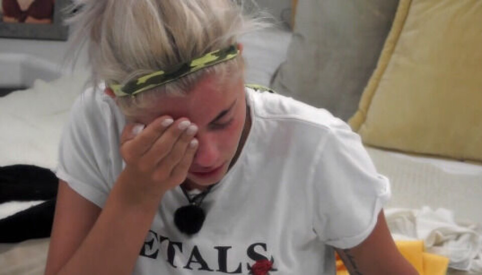 Sarah tager sig til hovedet, efter Türker har kastet en vandflaske i hovedet på hende (Foto: TV3/Viaplay)