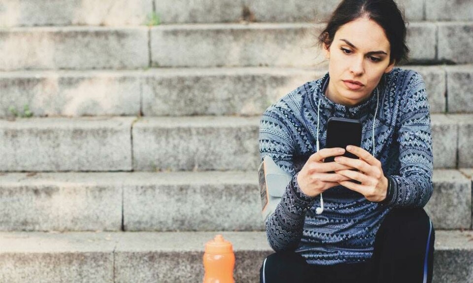 kvinde på trappe med mobiltelefon