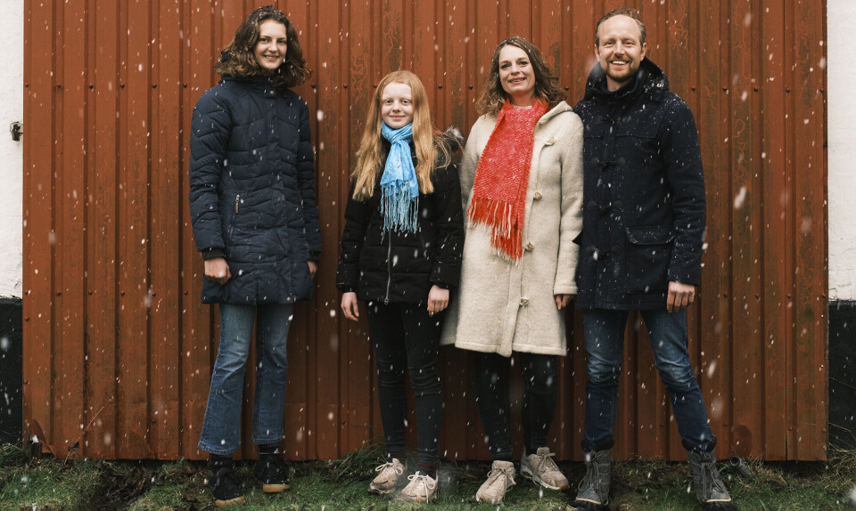 De fire medlemmer af Familien Weitze står foran en rød trævæg