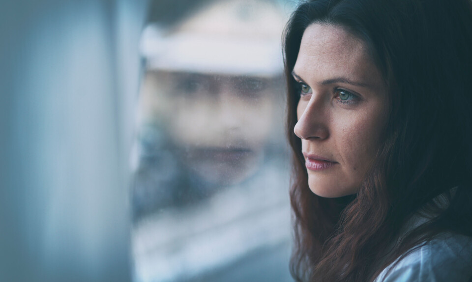 kvinde kigger ud af vindue