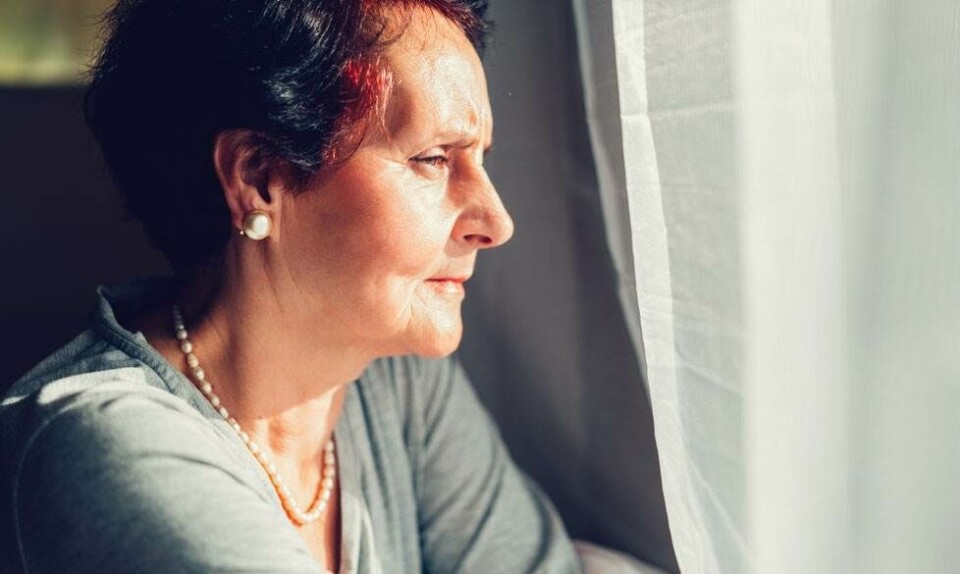 Kvinde kigger ud af vindue