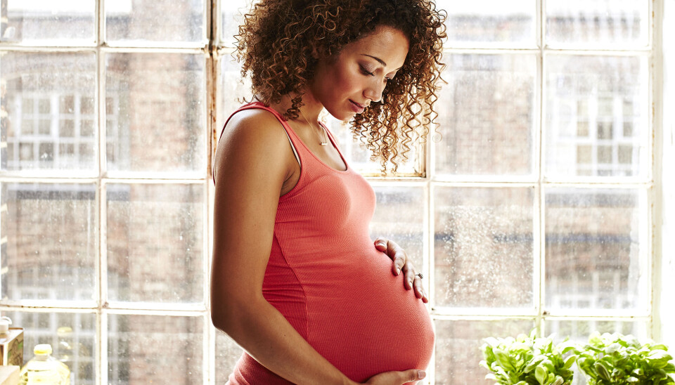 Gravid kvinde, som holder på sin mave.