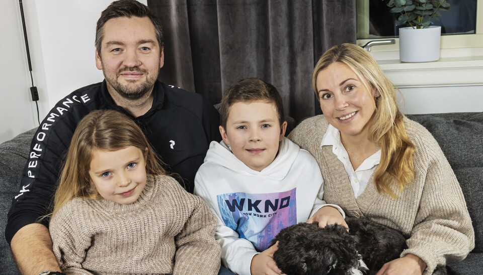 Williams familie. Far Fredrik, mor Sofia og lillesøsteren Greta, og deres hun Einar på 1,5 år. De sidder i en grå sofa sammen.