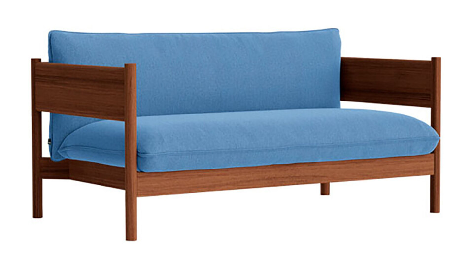 Et billede af en salonsofa, i mørkt træ og blå hynder.