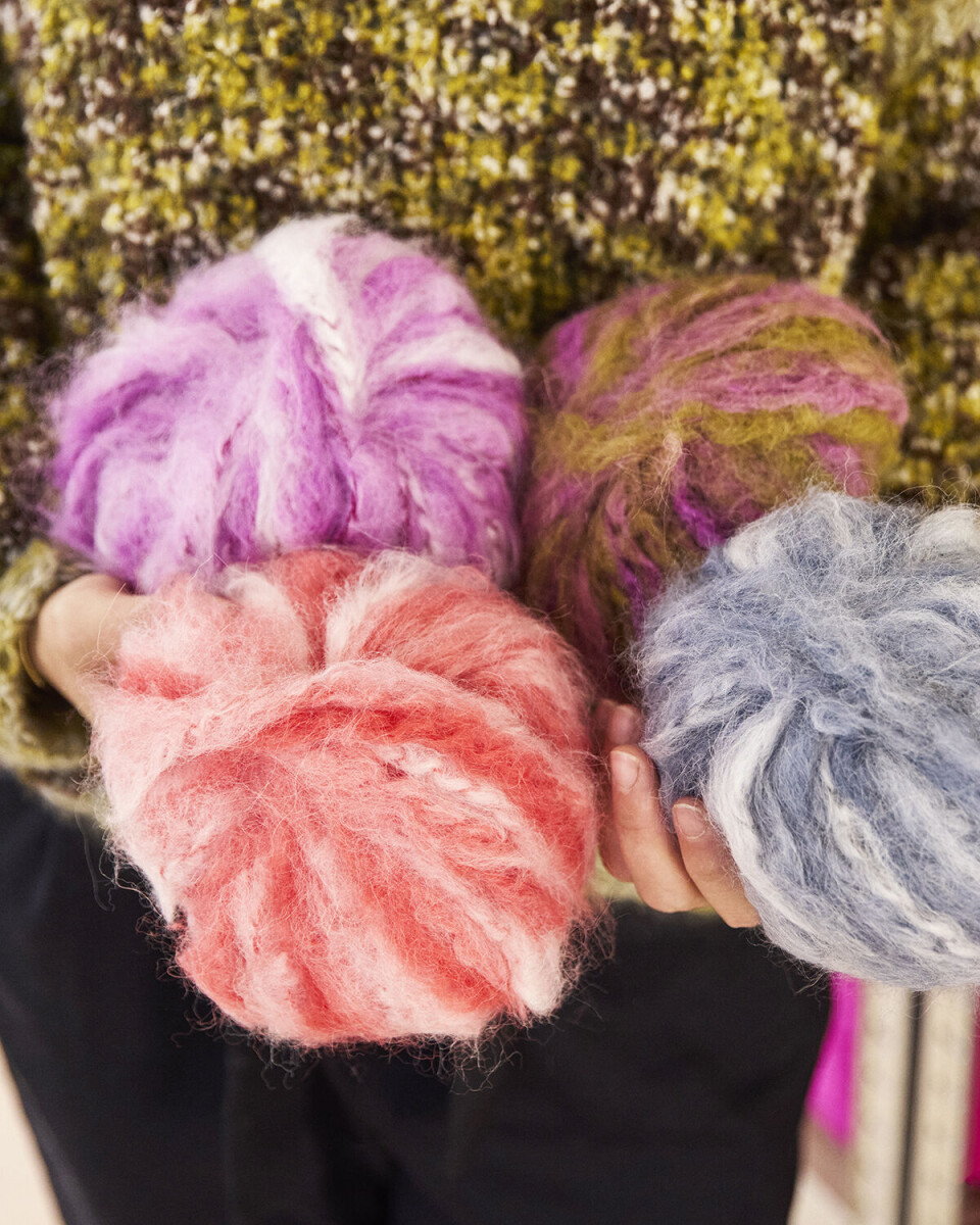 Et nærbillede af noget af det overskudsgarn, som Zuzana Obel har fået fat i. Der er fire garnruller, en i blå, en i lyserød, en i lilla, og en i grøn/lyserød.