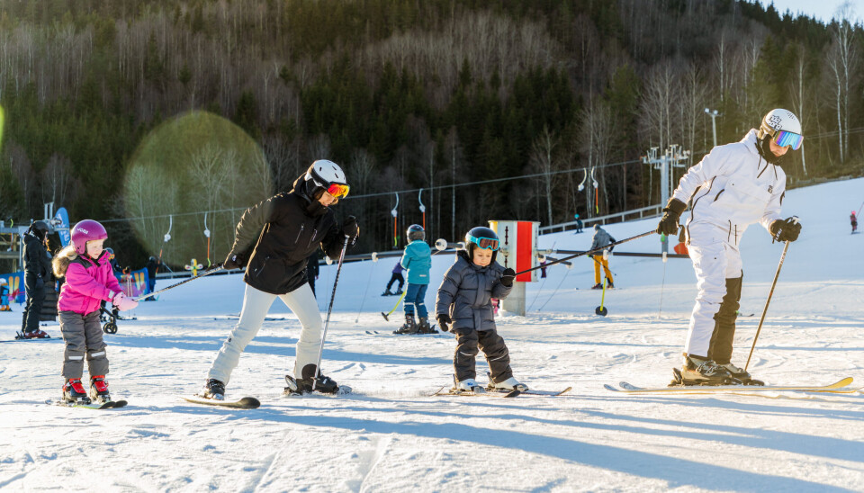 En familie på ski. Tre børn og en forælder.