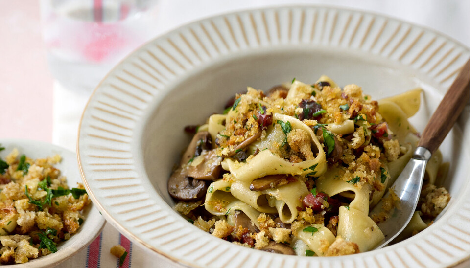 Pasta med svampe, pancetta og sprøde brødkrummer i en dyb tallerken