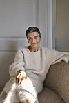 Margrethe Vestager sidder i en sofa iført et sæt tøj i blødt, fluffy materiale.